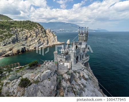 Crimea Swallow's Nest Castle on the rock over the Black Sea. It is a tourist attraction of Crimea. Amazing aerial view of the Crimea coast with the castle above abyss on sunny day. 100477945