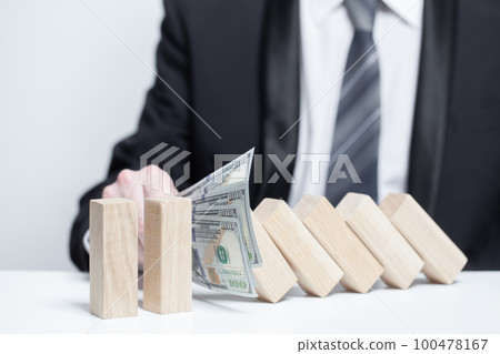 Wooden blocks under money us dollars protection, domino, insurance safety property concept 100478167