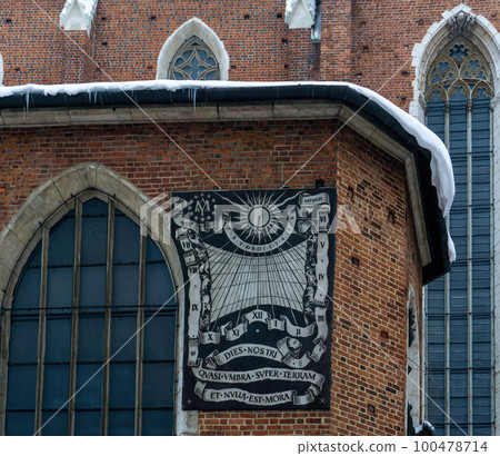Wall sundial on the brick wall of the ancient St. Mary's Cathedral in Krakow 100478714