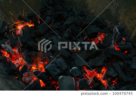 Coals with sparks in a huge old metal grill 100478745