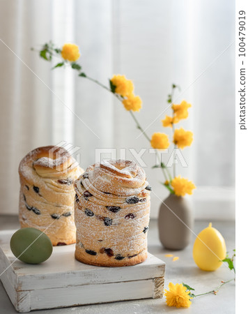 Easter layered cake Cruffin and yellow flowers background. Easter holidays composition Easter layered cake Cruffin and yellow flowers background. Easter holidays composition 100479019