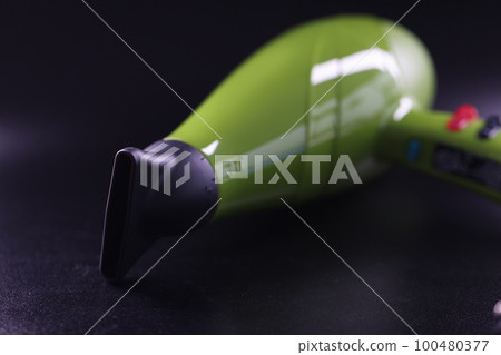 Professional hair dryer of bright green color on gray background closeup 100480377