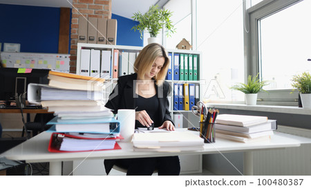 Businesswoman or secretary in office and stamping document Businesswoman or secretary in office and stamping document 100480387