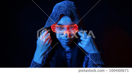 Portrait of young girl that is in eyeglasses in blue neon lighting Portrait of young girl that is in eyeglasses in blue neon lighting 100480671