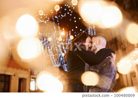 Happy multiracial couple together outdoors in the city celebrating New year 100480809