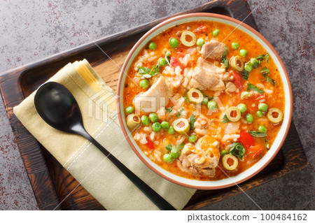 Asopao de Pollo this comforting Puerto Rican chicken and rice gumbo dish is loved throughout the Caribbean closeup on the bowl. Horizontal top view Asopao de Pollo this comforting Puerto Rican chicken and rice gumbo dish is loved throughout the Caribbean closeup on the bowl. Horizontal top view 100484162