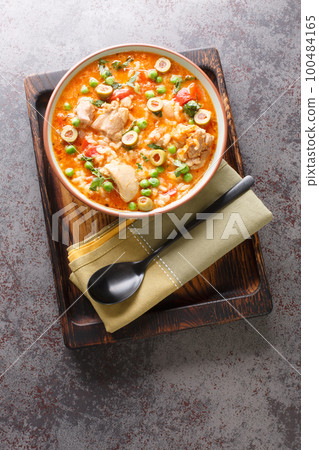 Traditional Puerto Rican Asopao de Pollo chicken and rice stew is filling and flavorful closeup on the bowl. Vertical top view 100484165