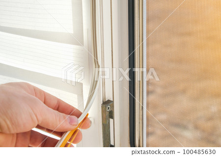 The man wipes the window frame with a degreaser 100485630