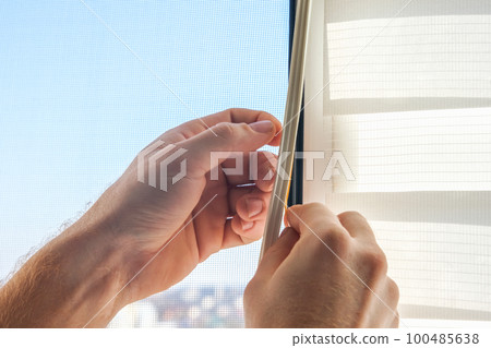 The man wipes the window frame with a degreaser 100485638