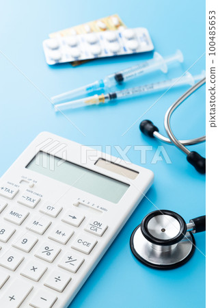 Stethoscope and calculator Blue background Stethoscope and calculator Blue background 100485653