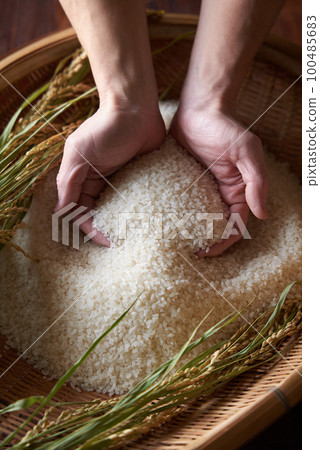 用手把米飯舀到漏勺裡 100485683