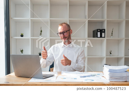 Handsome business man working using computer and paper happy with big smile doing, thumb up with fingers, excellent sign Handsome business man working using computer and paper happy with big smile doing, thumb up with fingers, excellent sign 100487523