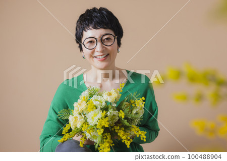 Middle woman with mimosa bouquet 100488904