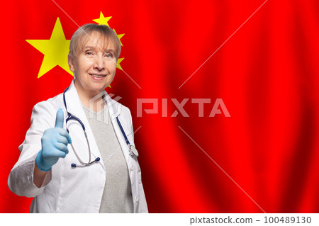 Chinese smiling mature doctor woman holding stethoscope on flag of China background Chinese smiling mature doctor woman holding stethoscope on flag of China background 100489130