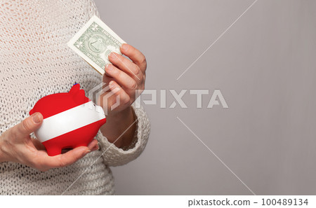 Flag of Austria on money bank in Austrian woman hands. Flag of Austria on money bank in Austrian woman hands. 100489134