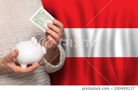 Austrian woman with money bank on the background of Austria flag. Dotations, pension fund,  100489137