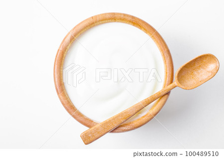 The Fresh greek yogurt in wooden bowl with wooden spoon on white background. Healthy breakfast. 100489510