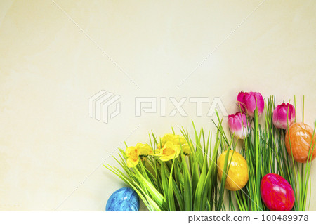 Colorful easter eggs with flowers and green grass. Easter eggs disappear on light yellow background. . Easter Holiday, egg hunting concept Colorful easter eggs with flowers and green grass. Easter eggs disappear on light yellow background. . Easter Holiday, egg hunting concept 100489978
