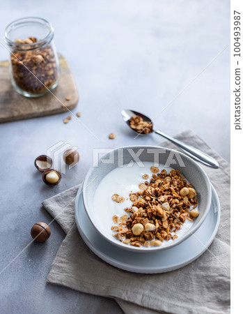 natural white yogurt with granola, macadamia in bowl 100493987