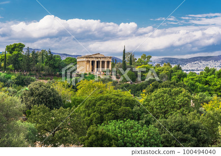Athens Greece Temple Of Hephaestus day view surrounded by greenery on a bright sunshine over puffy clouds. Athens Greece Temple Of Hephaestus day view surrounded by greenery on a bright sunshine over puffy clouds. 100494040