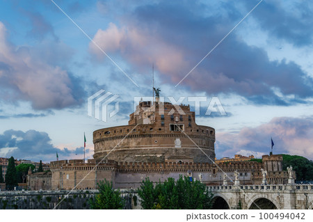 Rome Italy Castel SantAngelo evening view with Ponte SantAngelo pedestrian bridge visible and puffy clouds above. 100494042