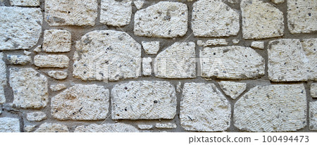 Sturdy yellow and beige cut stone wall, seamless lined up Sturdy yellow and beige cut stone wall, seamless lined up 100494473