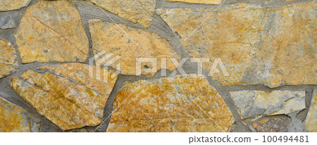 Sturdy yellow and beige cut stone wall, seamless lined up Sturdy yellow and beige cut stone wall, seamless lined up 100494481