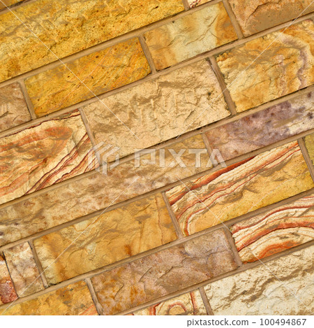 Sturdy yellow and beige cut stone wall, seamless lined up 100494867