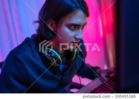 Handsome boy playing E-Sport game or streamer, Enjoying playing online games, Entertainment or technology game trends, Live show play games, Focus monitor, Blue and red lights Handsome boy playing E-Sport game or streamer, Enjoying playing online games, Entertainment or technology game trends, Live show play games, Focus monitor, Blue and red lights 100495166
