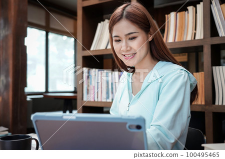 Female student is using calculator to doing homework assignment of finance and accounting while sitting Female student is using calculator to doing homework assignment of finance and accounting while sitting 100495465