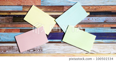 On a multi-colored wooden background are colored stickers. On a multi-colored wooden background are colored stickers. 100501534