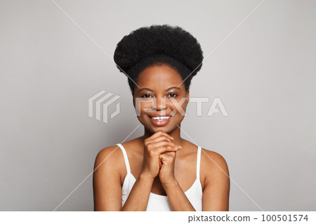 Cute young brunette model woman with clean healthy fresh dark skin smiling against white studio 100501574