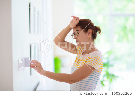Woman adjusting thermostat. Central heating. Woman adjusting thermostat. Central heating. 100502269