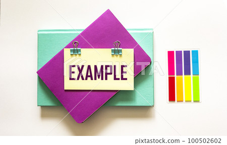 Example, the word is written on a sticker and a white background. The sticker lies on the example Example, the word is written on a sticker and a white background. The sticker lies on the example 100502602