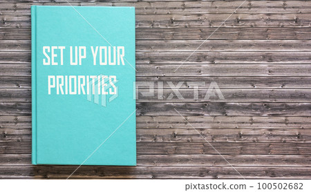 Green notepad with text Prioritize on wooden background Green notepad with text Prioritize on wooden background 100502682
