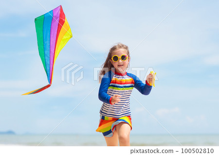 Child with kite. Kids play. Family beach vacation. 100502810