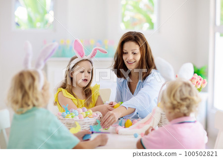 Mother and kids, family coloring Easter eggs. 100502821
