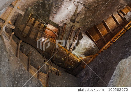 Krakow, Poland Wieliczka salt mine - Kopalnia soli Wielicska - illuminated interior top view, with wooden ladder leading to the scenic tourist route. Krakow, Poland Wieliczka salt mine - Kopalnia soli Wielicska - illuminated interior top view, with wooden ladder leading to the scenic tourist route. 100502970