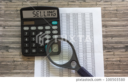 The text for Selling written on a calculator, next to a magnifying glass and reports in numbers The text for Selling written on a calculator, next to a magnifying glass and reports in numbers 100503580