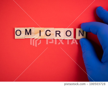 Omicron variant replaces Delta. Emergence of new dangerous strain of coronavirus COVID-19 Omicron. Blue gloves on hand. Words omicron on colored red background 100503728