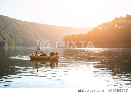 Tourist on yellow packraft boat with red padle Tourist on yellow packraft boat with red padle 100504257
