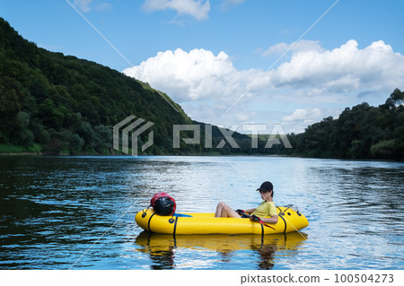 Young boy on yellow packraft boat 100504273