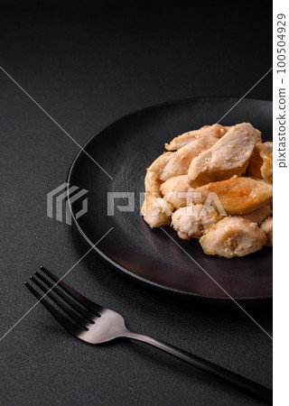 Delicious chicken slices baked with spices and herbs on a round ceramic plate 100504929