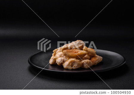 Delicious chicken slices baked with spices and herbs on a round ceramic plate 100504930
