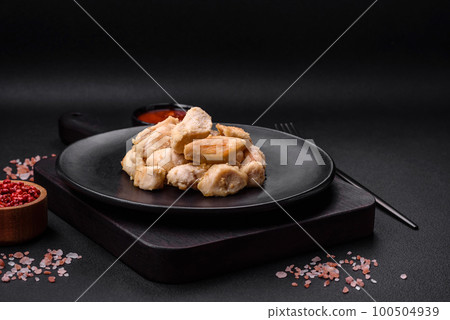 Delicious chicken slices baked with spices and herbs on a round ceramic plate 100504939