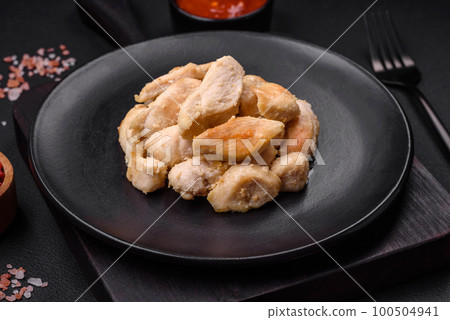 Delicious chicken slices baked with spices and herbs on a round ceramic plate Delicious chicken slices baked with spices and herbs on a round ceramic plate 100504941