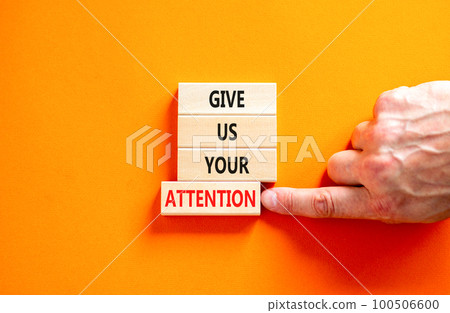 Give us your attention symbol. Concept words Give us your attention on wooden block. Beautiful orange table orange background. Motivational business give us your attention concept. Copy space. 100506600