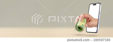 Earning money on the Internet. The hand holds a roll of money. A lot of euro bills in the hand, the hand climbs out of a modern mobile phone. The concept of working on the Internet 100507160