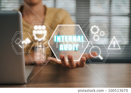 Internal audit concept, Person working on laptop computer and hand holding internal audit icon on virtual screen. Internal audit concept, Person working on laptop computer and hand holding internal audit icon on virtual screen. 100513678