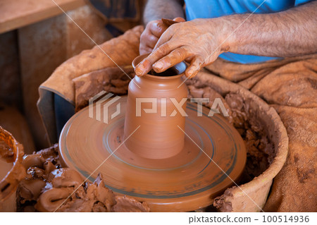 Hands working on pottery wheel 100514936